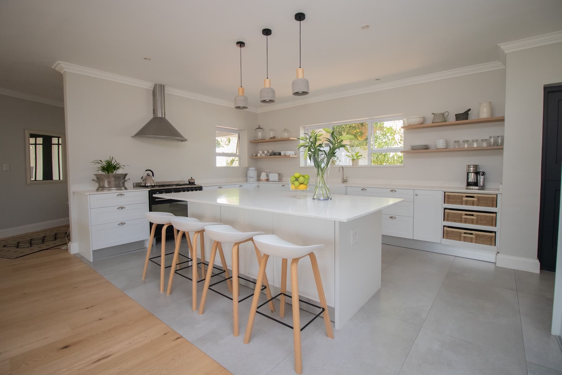 A bright kitchen with white cabinetry, a central island and open counters